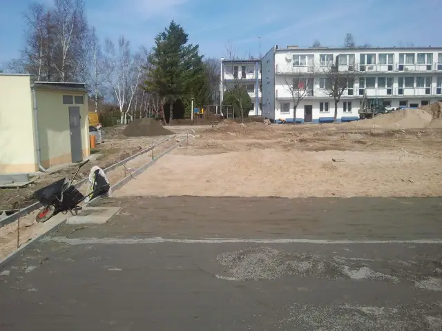 Przygotowany piaszczysty plac pod nawierzchnię boiska obok budynków ośrodka wypoczynkowego