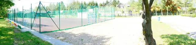Widok całego kompleksu boisk rekreacyjnych z siatkowym ogrodzeniem w O.W. Neptun