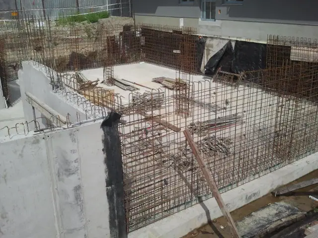 Naroże betonowej ściany z gęstą klatką zbrojeniową przygotowaną pod kolejny etap prac