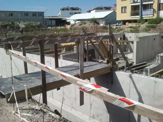 Ukośne podpory szalunkowe stabilizują świeżo wylane ściany fundamentowe budynku SZYMETA