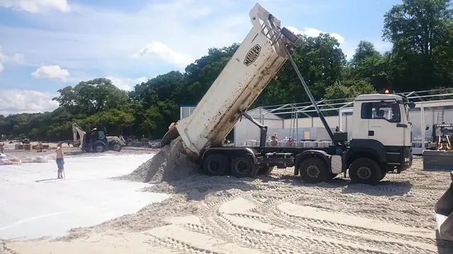 Wywrotka wysypuje piasek na plaży w trakcie przygotowań do zawodów Cavaliada w Kołobrzegu