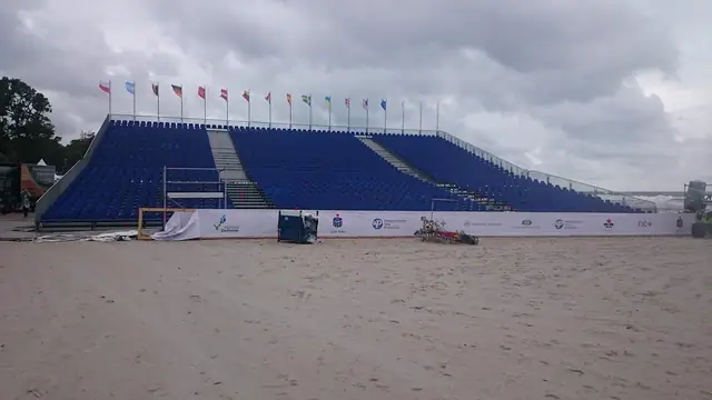Niebieskie trybuny widowni z flagami gotowe do zawodów Cavaliada Summer Jumping na plaży w Kołobrzegu