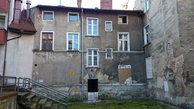 Zabity deskami budynek dawnej kamienicy przy ulicy Cichej w Kołobrzegu przed rozbiórką
