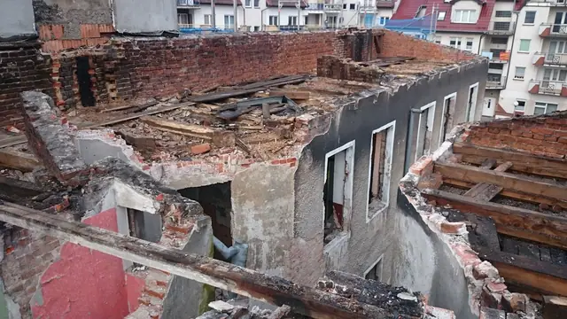 Odsłonięty szkielet dachu i górne piętra kamienicy po zdjęciu pokrycia dachowego