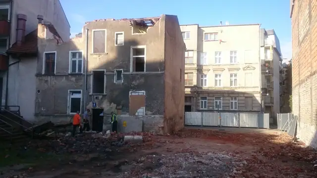 Samotna ściana szczytowa pozostała po rozbiórce, w tle rusztowanie sąsiedniego budynku
