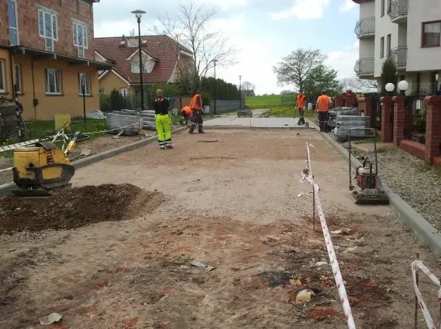 Robotnicy układają krawężniki na podbudowie żwirowej przyszłej drogi gminnej w Rewalu