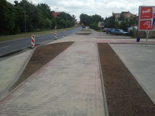 Wykończona wysepka z kostki brukowej i rabatą ziemną przy markecie Polo w Rewalu