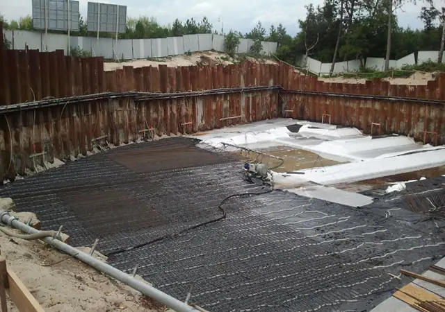 Wykop z folią izolacyjną i zbrojeniem w trakcie wylewki fundamentowej hotelu w Mielnie