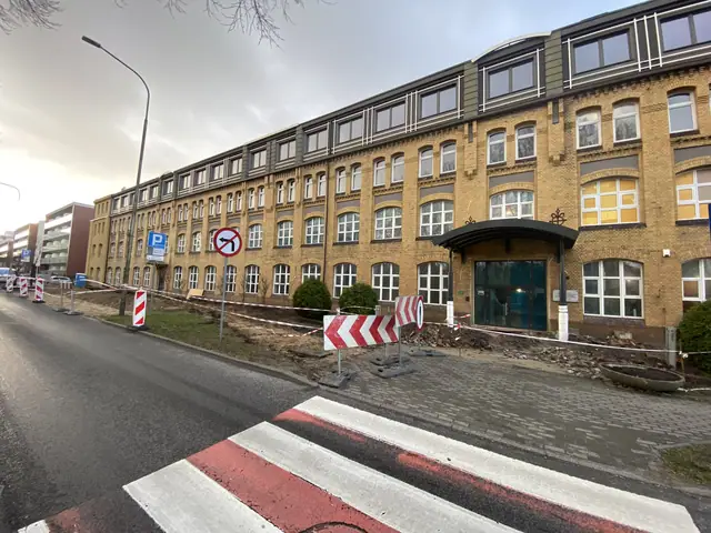 Zabytkowy ceglany budynek Factory Resort w Kołobrzegu odgrodzony barierkami podczas modernizacji