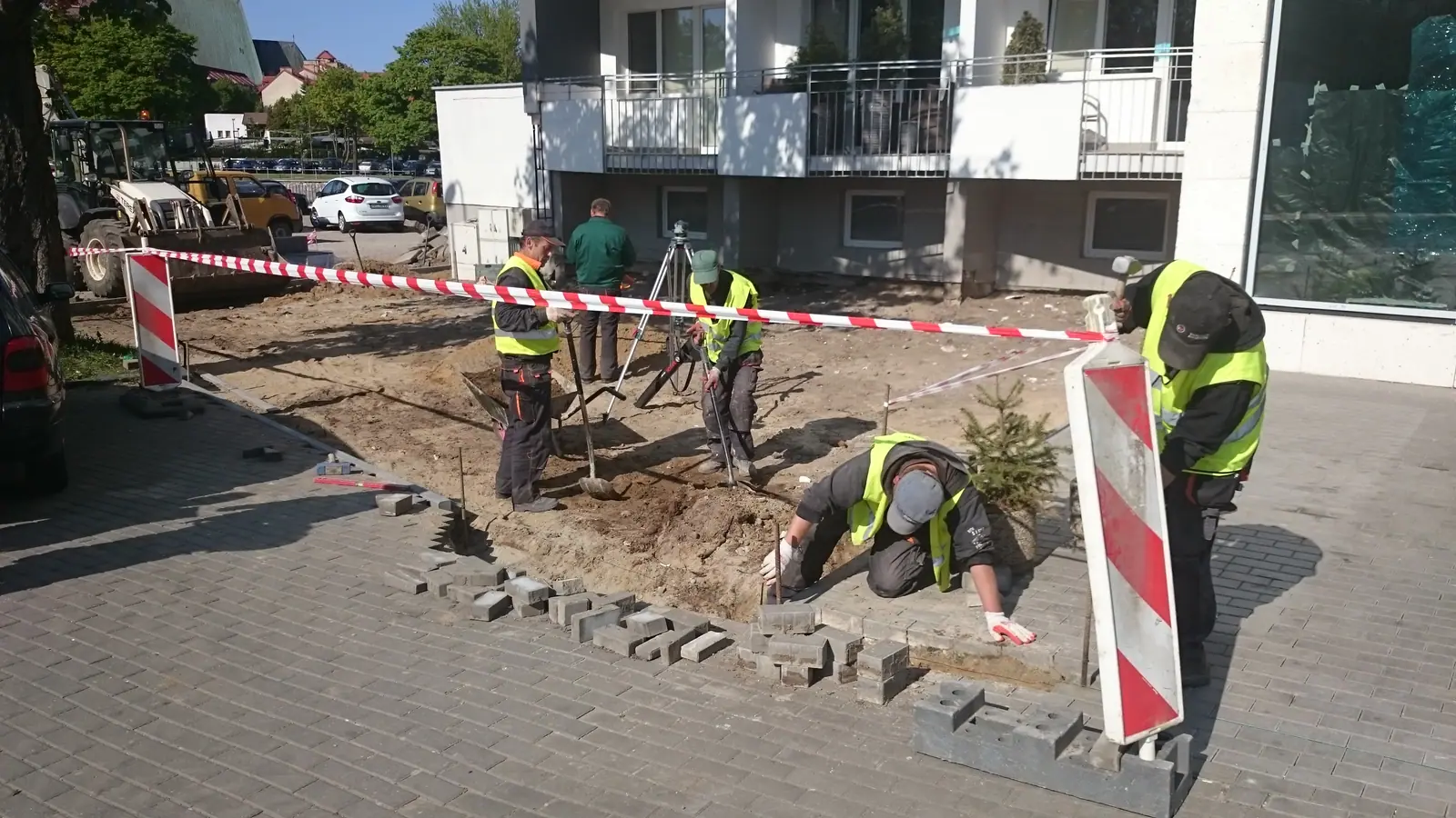Ekipa w kamizelkach odblaskowych układa krawężnik betonowy przy głównym wejściu do Hotelu nad Parsętą