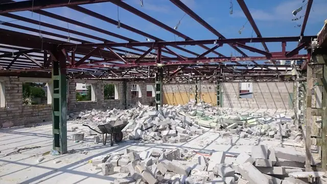 Stalowa konstrukcja dachu hali bez ścian nad stertami gruzu betonowego