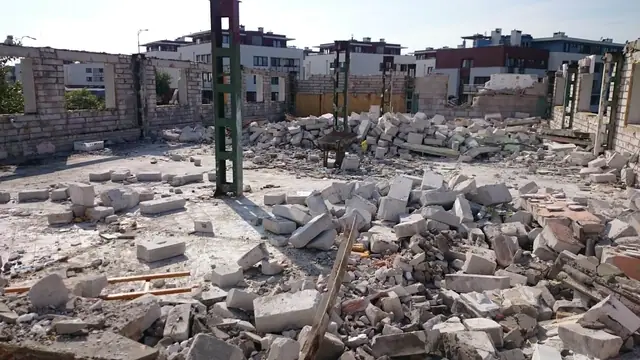 Sterty gruzu betonowego rozłożone między stalowymi słupami konstrukcji hali
