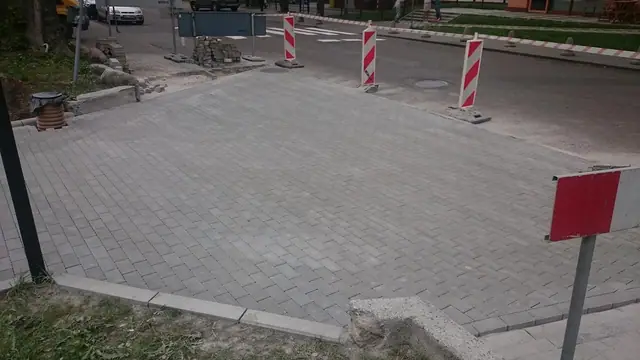 Gotowa nawierzchnia z kostki brukowej na skwerze zabezpieczona pachołkami drogowymi
