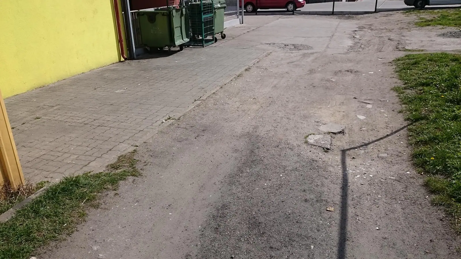 Popękana i zapadnięta stara nawierzchnia asfaltowa chodnika przed wymianą przy ulicy Okopowej