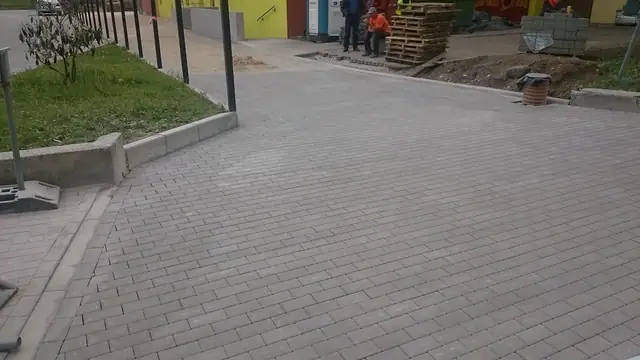 Ukończony fragment nowej nawierzchni z kostki brukowej przy trawniku