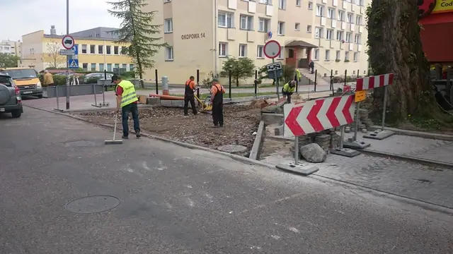Ekipa zagęszcza nawierzchnię przy oznakowaniu drogowym i znaku zakazu wjazdu