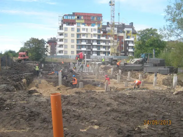 Robotnicy przy słupach fundamentowych bloku, w tle żuraw wieżowy na budowie Osiedla pod Lipami