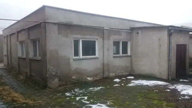 Płaskodachowy otynkowany budynek dawnej bazy PKS zanim ruszyły prace rozbiórkowe