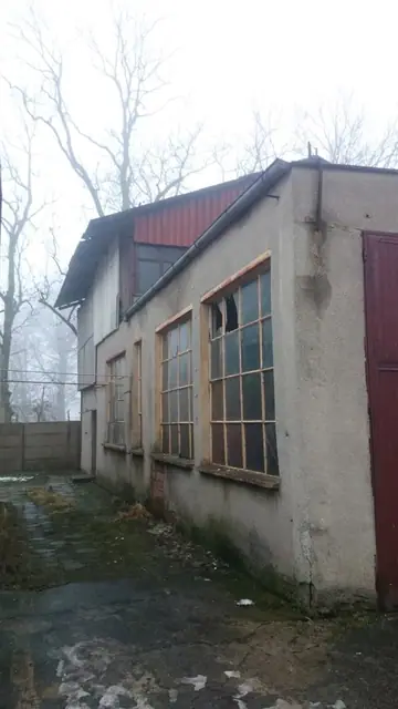 Stary otynkowany budynek bazy PKS z drewnianymi oknami i czerwonym dachem przed rozbiórką