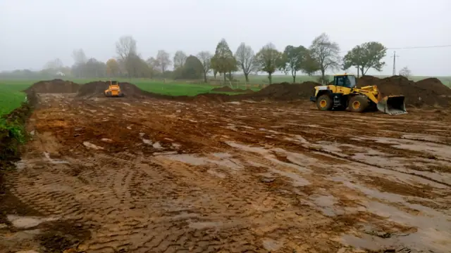 Ładowarka kołowa równa rozjeżdżony, błotnisty teren pod plac składowy