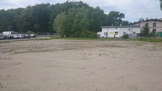 Wyrównany piaszczysty plac pod przyszły parking przy markecie w Mielnie