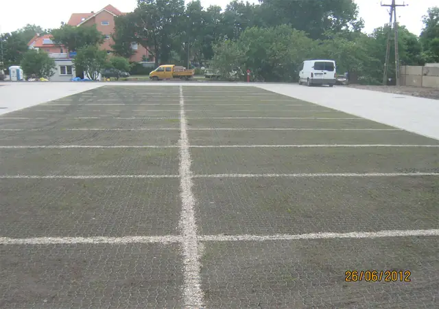 Gotowy parking z geokraty trawnikowej z wyznaczonymi białymi liniami miejsc postojowych