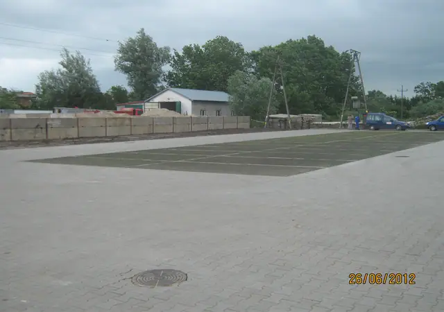 Gotowy parking z kraty trawnikowej z wyraźnie wyznaczonymi miejscami postojowymi przy markecie
