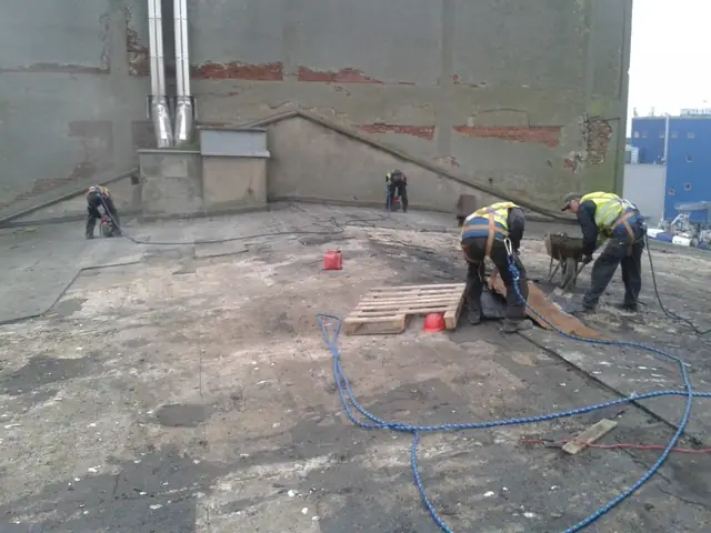 Pracownicy z młotami pneumatycznymi rozbierają strop budynku portowego