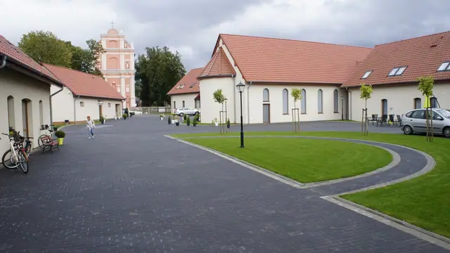 Baner wykonawcy Szymeta na bramie ogrodzeniowej przed jeszcze niewykończonym fragmentem terenu