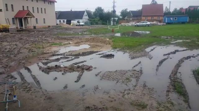 Rozległe kałuże i grzęzawisko na placu budowy obok zabudowań sanktuarium w Skrzatuszu