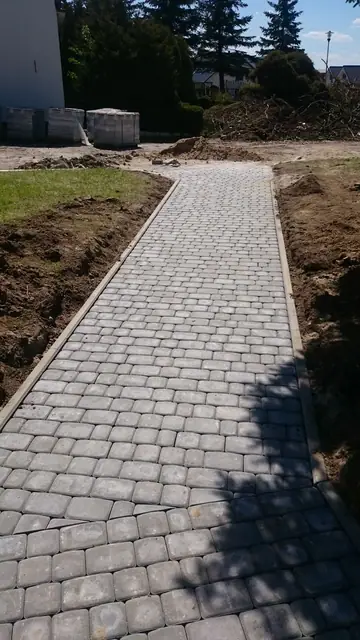 Nowo ułożony chodnik z kostki brukowej prowadzący przez teren ośrodka wypoczynkowego w Sianożętach