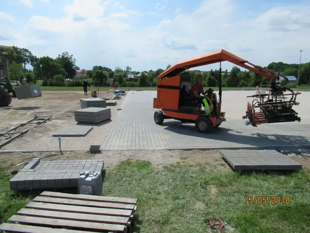 Mechaniczna układarka kostki brukowej rozkłada betonową kostkę w równych rzędach