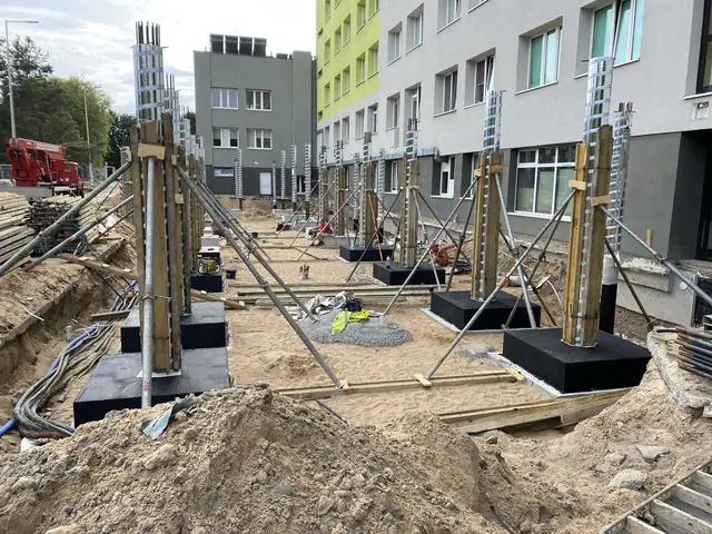 Stalowe słupy osadzone w betonowych stopach fundamentowych na terenie szpitala