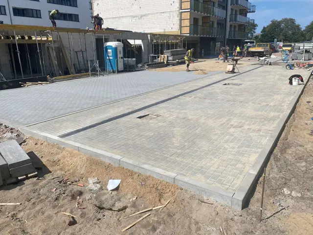 Gotowy plac z jasnej kostki brukowej przed nowo budowanym budynkiem mieszkalnym przy ul. Bałtyckiej