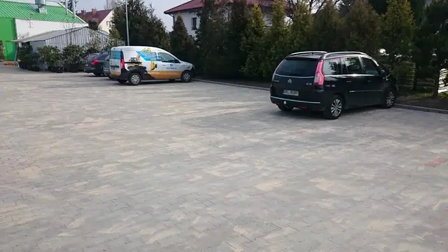 Gotowy parking z kostki betonowej z zaparkowanymi samochodami dostawczymi